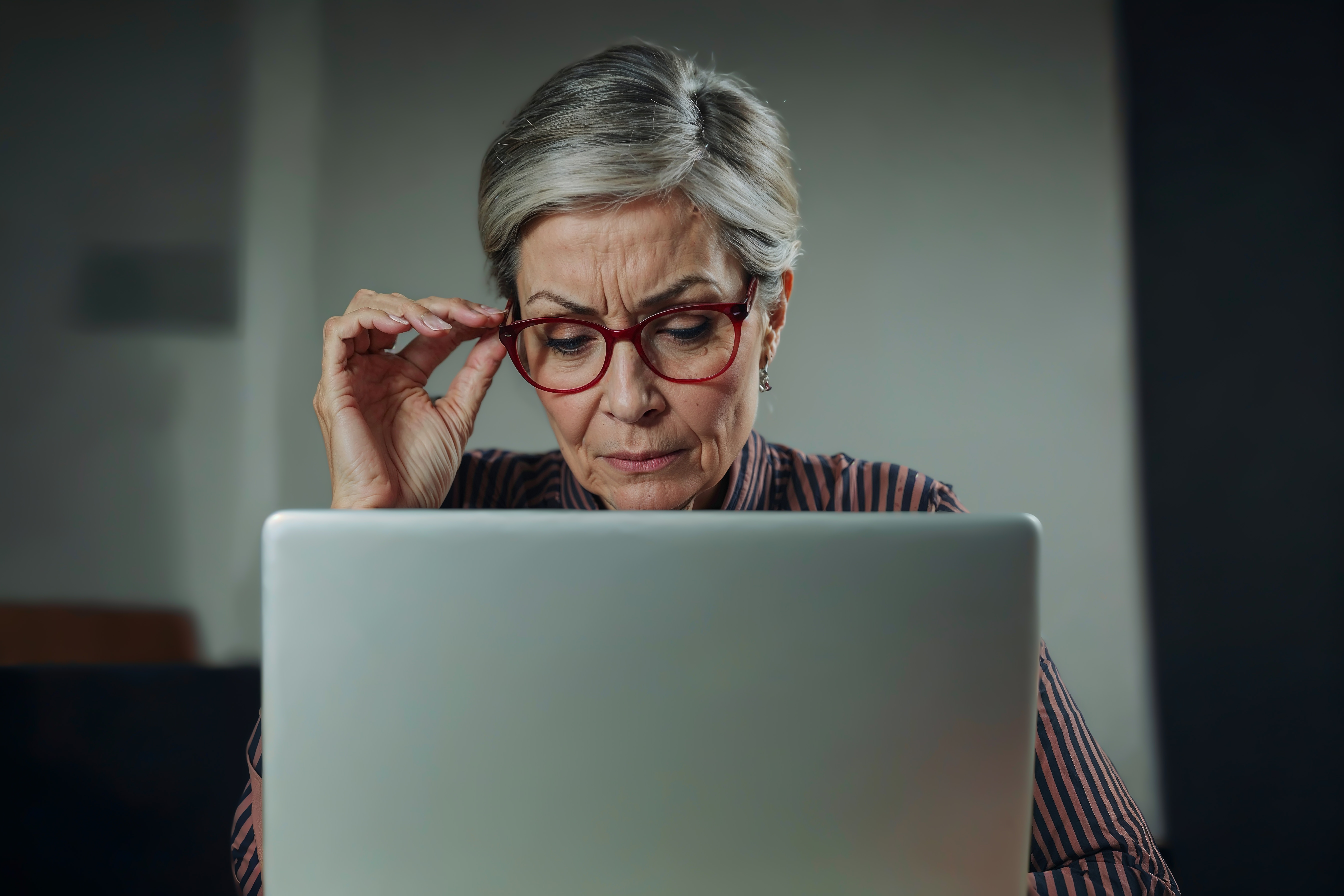 Femme qui plisse les yeux devant son écran
